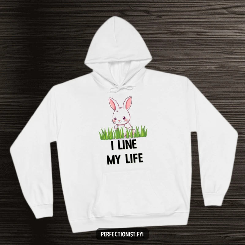 Funny Hoodie: A meticulous bunny carefully arranges individual blades of grass in a straight line, illustrating a humorous dedication to perfection.